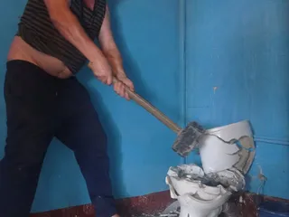 Пьяный мужик разбивает туалет кувалдой